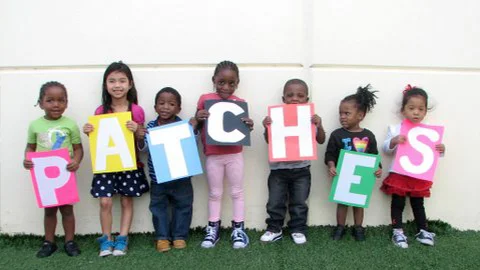 Patches. thank you. A group of kids holding sings with the Patches initials